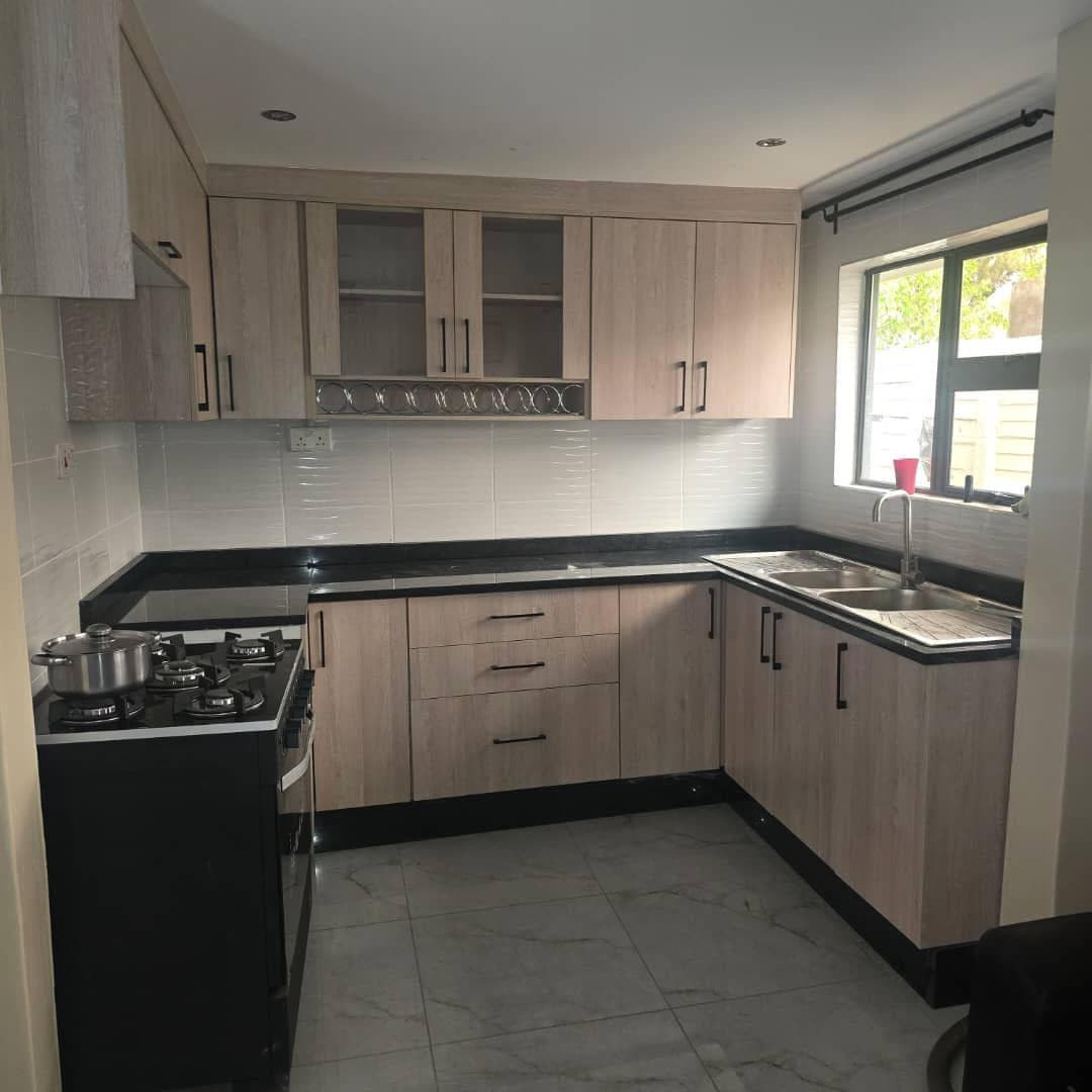 L-shaped oak-finish kitchen with black granite tops and an integrated wine rack.