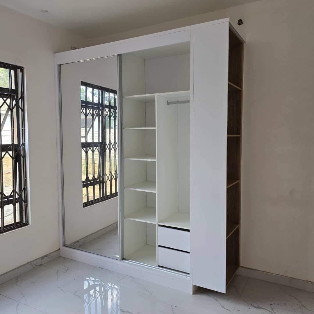 Stand-alone wardrobe with a sliding mirror door and open oak side shelving.